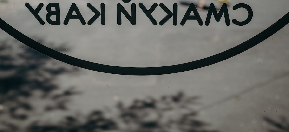 a close up of a sign with a person walking in the background
