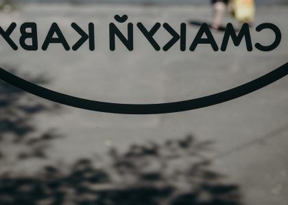 a close up of a sign with a person walking in the background